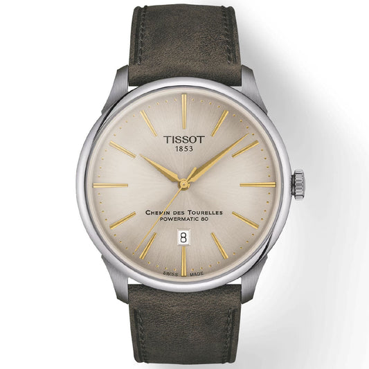 The Tissot Chemin Des Tourelles Powermatic 80 Automatic 42mm Watch showcases a silver dial, gold-tone hour markers, and a date window positioned at 6 o'clock. It is equipped with a robust 316L stainless steel case and complemented by a dark leather strap, while being powered by the dependable Powermatic 80 movement.