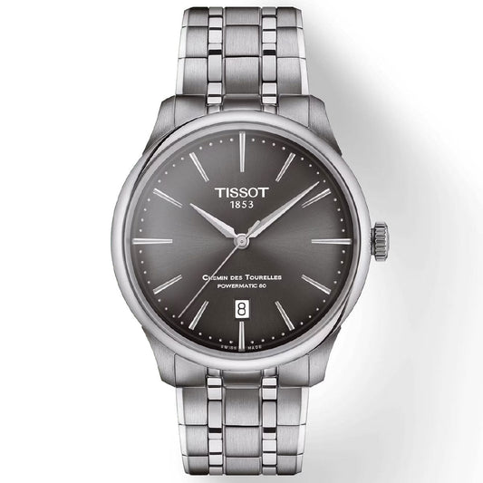 The Tissot Chemin Des Tourelles Powermatic 80 Automatic 39mm Watch features a Swiss automatic movement, stainless steel bracelet, and a black dial. Silver hour markers, slim hands, and a date window at the 6 o'clock position adorn the watch face. A sapphire crystal covers the dial, elegantly showcasing the Tissot logo and "1853.