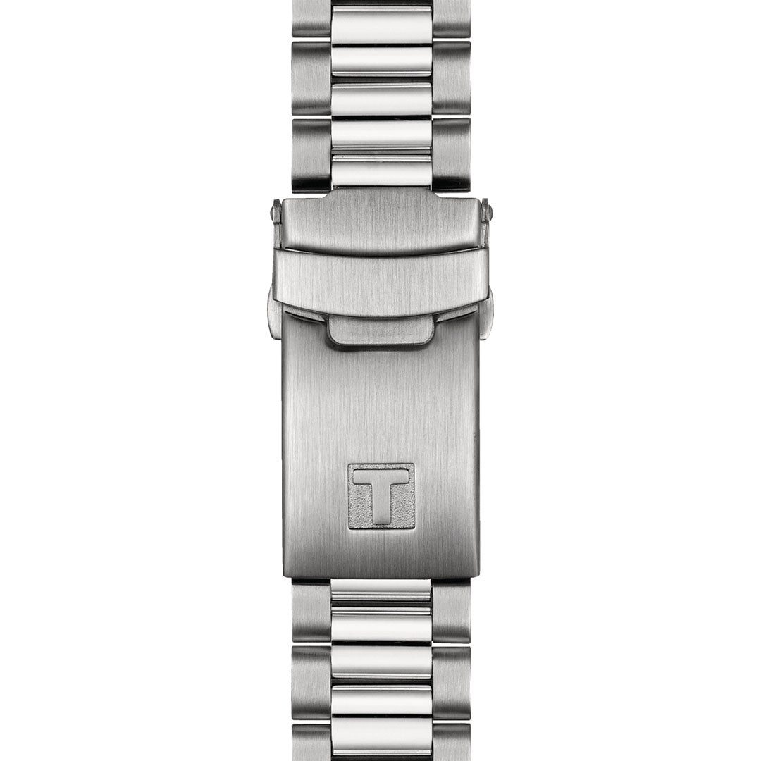 The Tissot PR516 Chronograph Quartz 40mm Watch band features a close-up of the clasp adorned with a refined "T" logo. Its sleek and polished design highlights alternating shiny and brushed metal links, encapsulating the timeless elegance synonymous with Tissot.