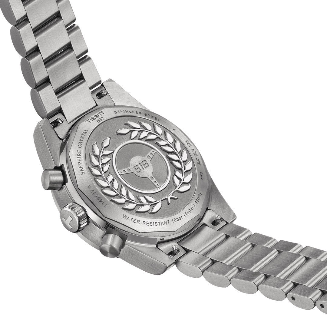 Close-up image of the back of a Tissot PR516 Chronograph Quartz 40mm Watch. This stainless steel wristwatch from Tissot features an engraved laurel wreath and text indicating water resistance up to 10 bar. The linked and polished metal bracelet showcases its interchangeable system.