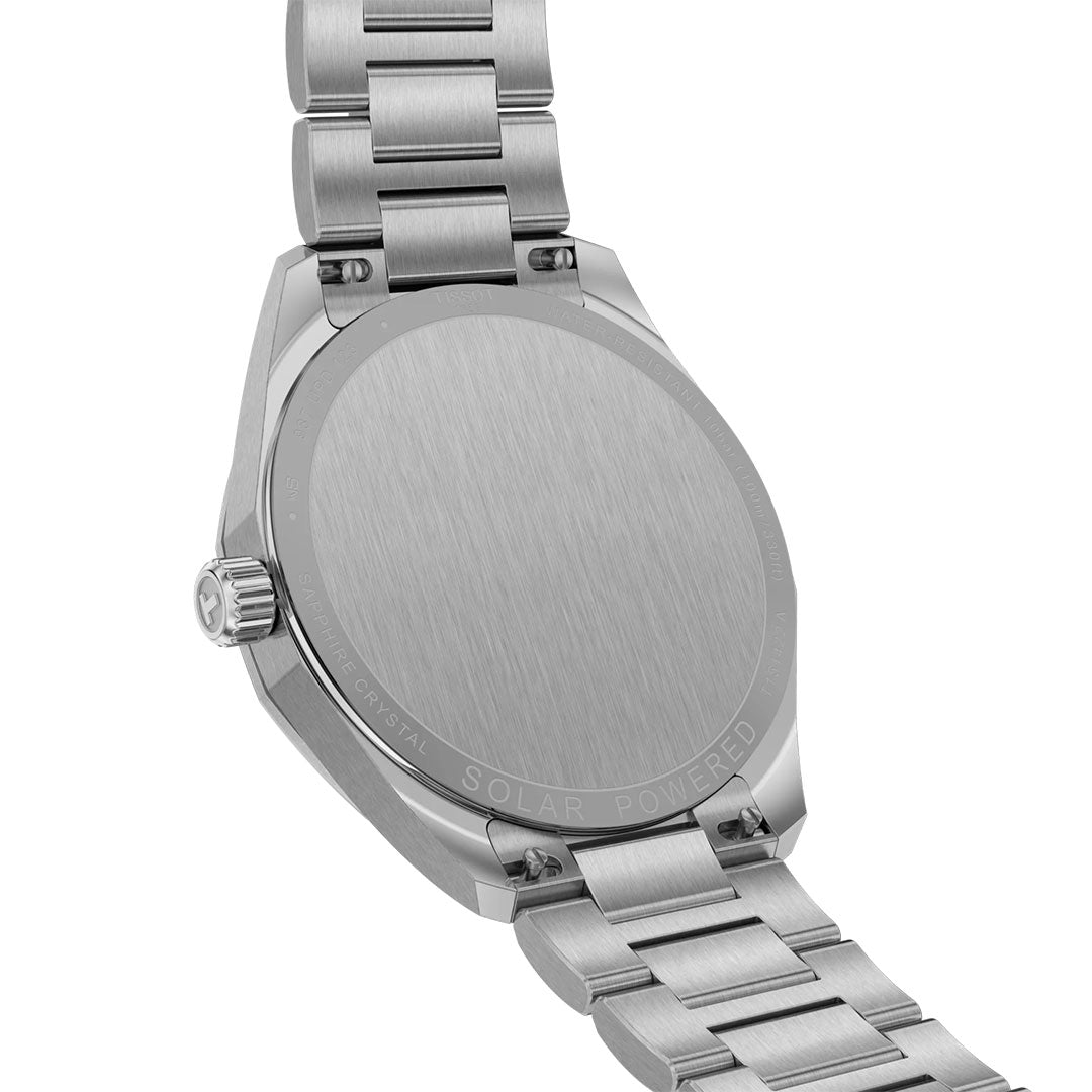 A close-up shows the back of the Tissot PRC 100 Solar Quartz 39mm Watch, featuring a brushed stainless steel finish, metal link band, and "SOLAR POWERED" engraved near the edge.