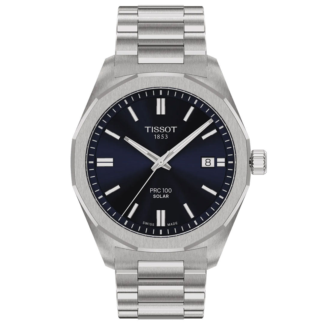 The Tissot PRC 100 Solar Quartz 39mm watch features a stainless steel case, blue dial with silver markers, date at 3 o'clock, metal link bracelet, and "Tissot 1853" branding on its solar-powered face.
