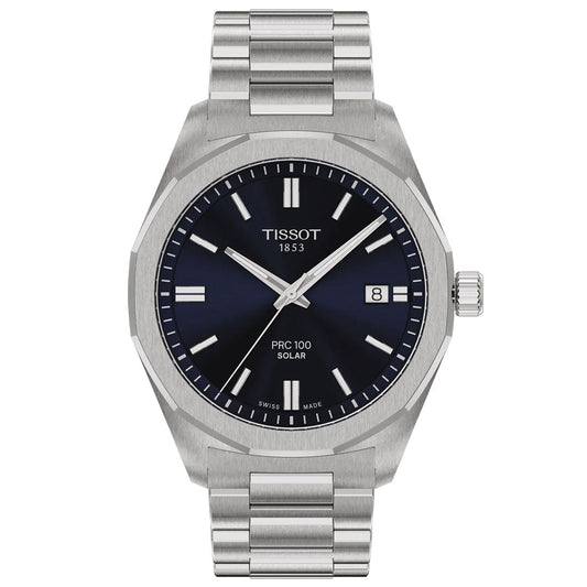 The Tissot PRC 100 Solar Quartz 39mm watch features a stainless steel case, blue dial with silver markers, date at 3 o'clock, metal link bracelet, and "Tissot 1853" branding on its solar-powered face.