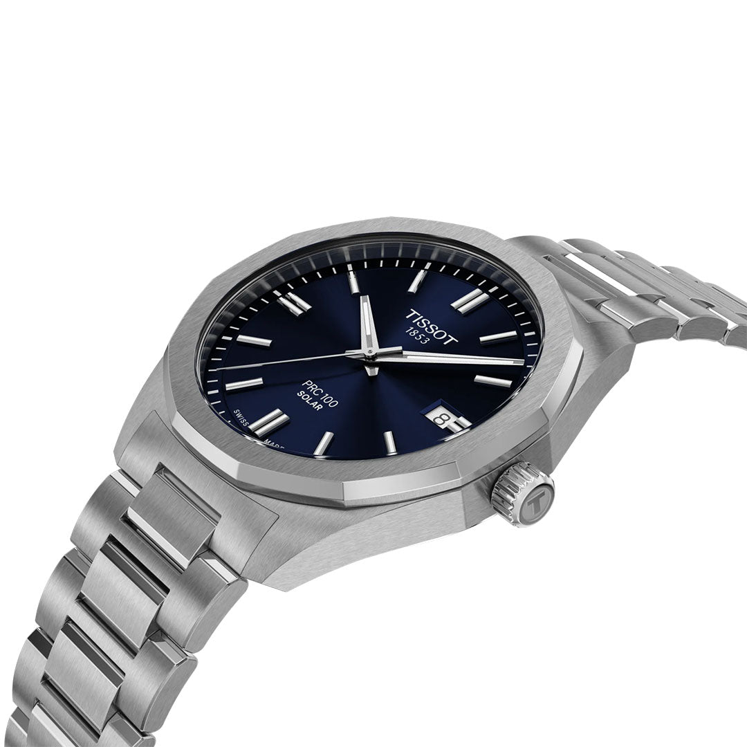 The Tissot PRC 100 Solar Quartz 39mm Watch features a stainless steel band, blue dial, silver hour markers, date at 3 o’clock, and the Tissot logo below 12 o’clock.