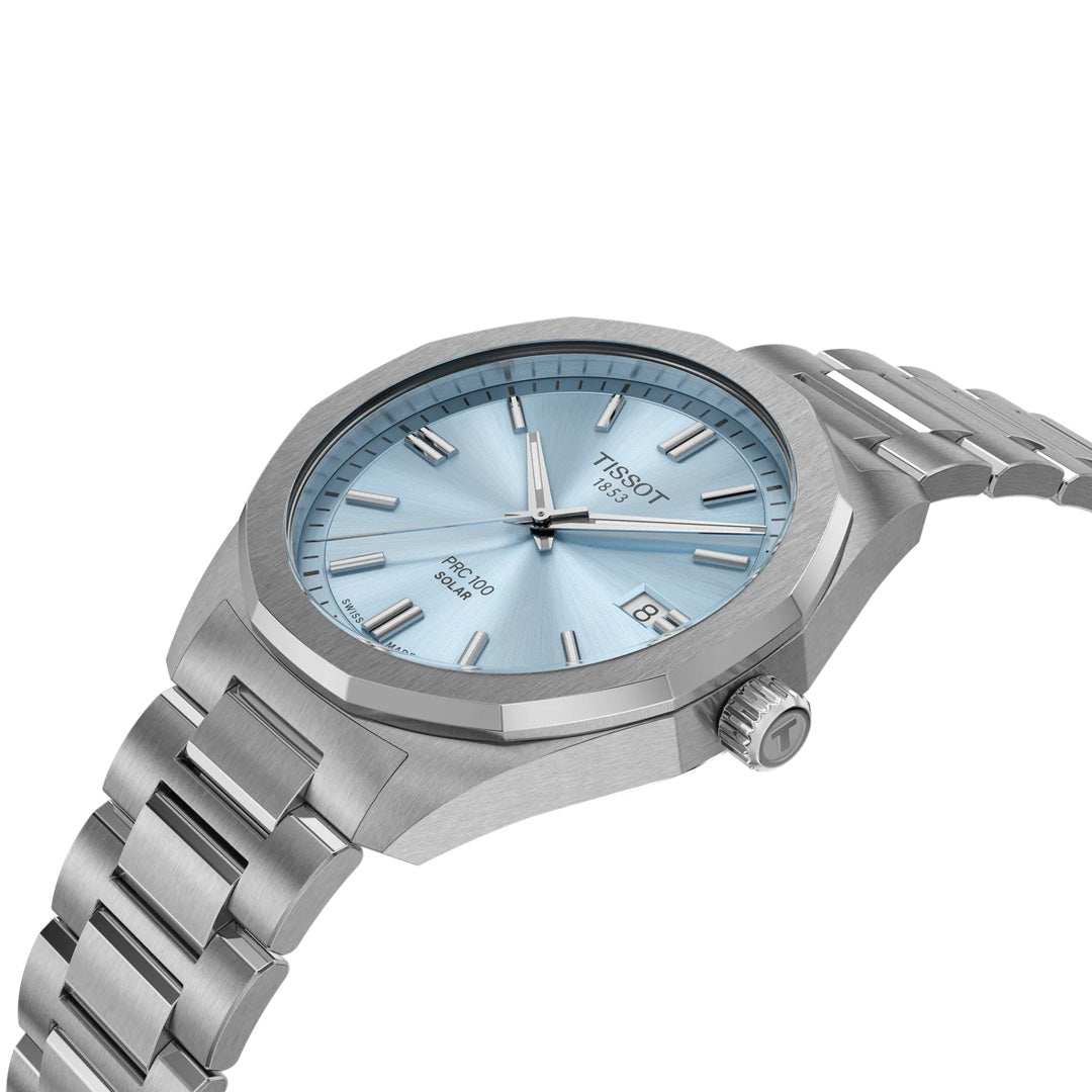 A silver Tissot PRC 100 Solar Quartz 39mm watch with a stainless steel bracelet and light blue dial, silver hands and markers, plus a date display at 3 o’clock. Shown angled on a white background.