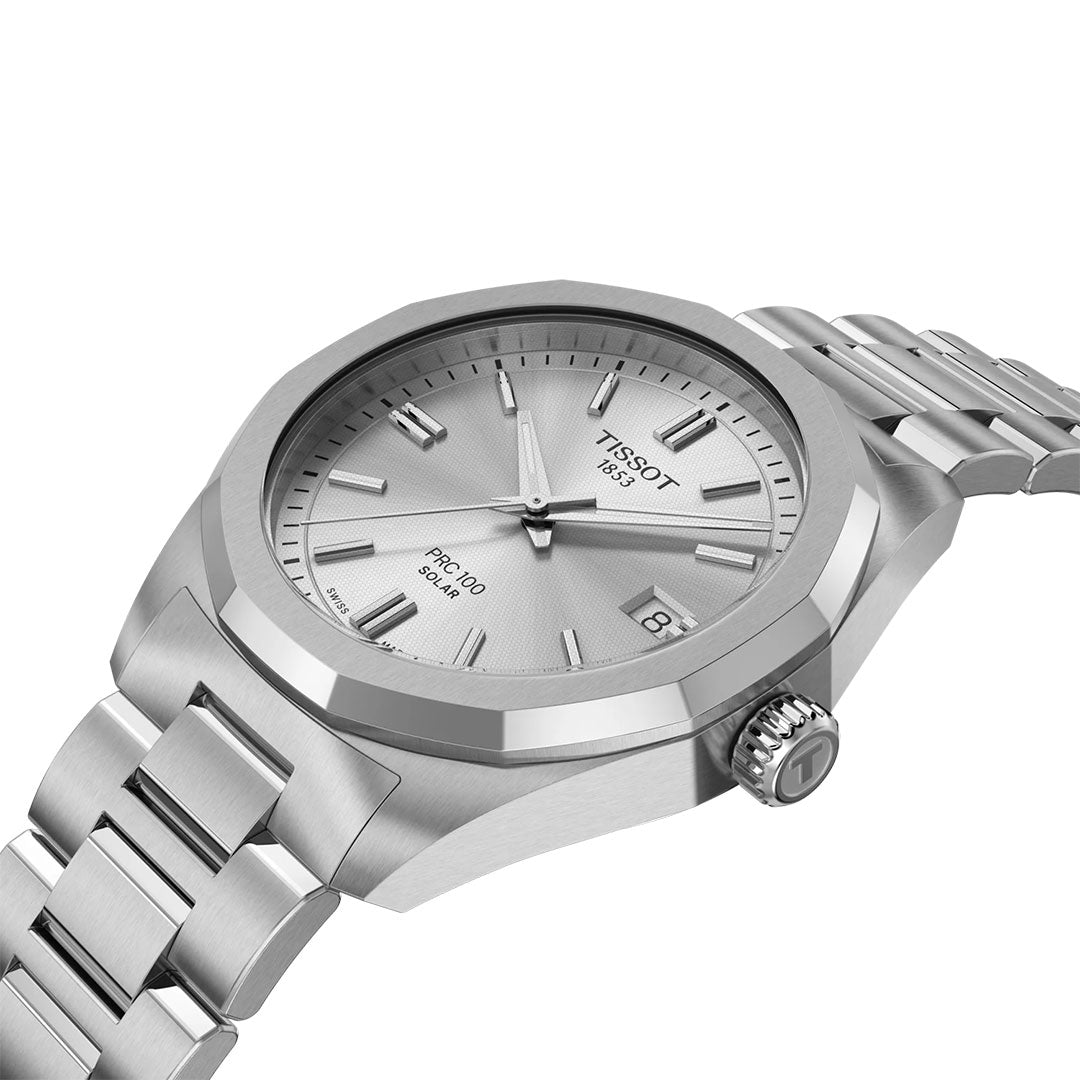 A close-up of the Tissot PRC 100 Solar Quartz 34mm Watch with a stainless steel band, silver dial, minimalist hour markers, and date display at 3 o’clock, set against a white background.