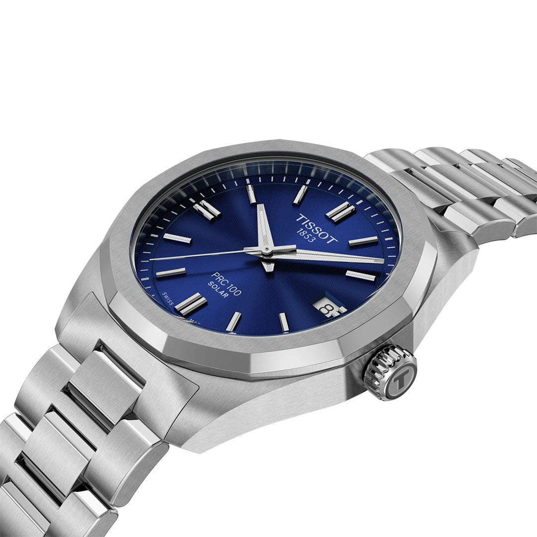 The Tissot PRC 100 Solar Quartz 34mm Watch features a silver stainless steel case, blue dial with silver markers and hands, date at 3 o’clock, and Tissot branding—a stylish solar-powered accessory for modern elegance.