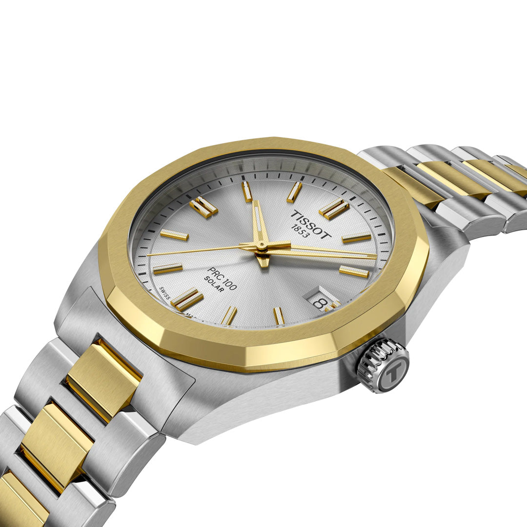 The Tissot PRC 100 Solar Quartz 34mm Watch features a silver dial, gold bezel, gold hour markers and hands, gold accents on the bracelet, and a date window at 3 o’clock.