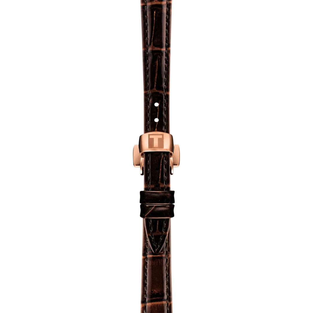 A Tissot Desir Automatic 28mm Watch is shown vertically against a white background, featuring a brown leather strap with crocodile pattern and a rose gold clasp bearing the "T" logo—ideal for pairing with automatic movement.