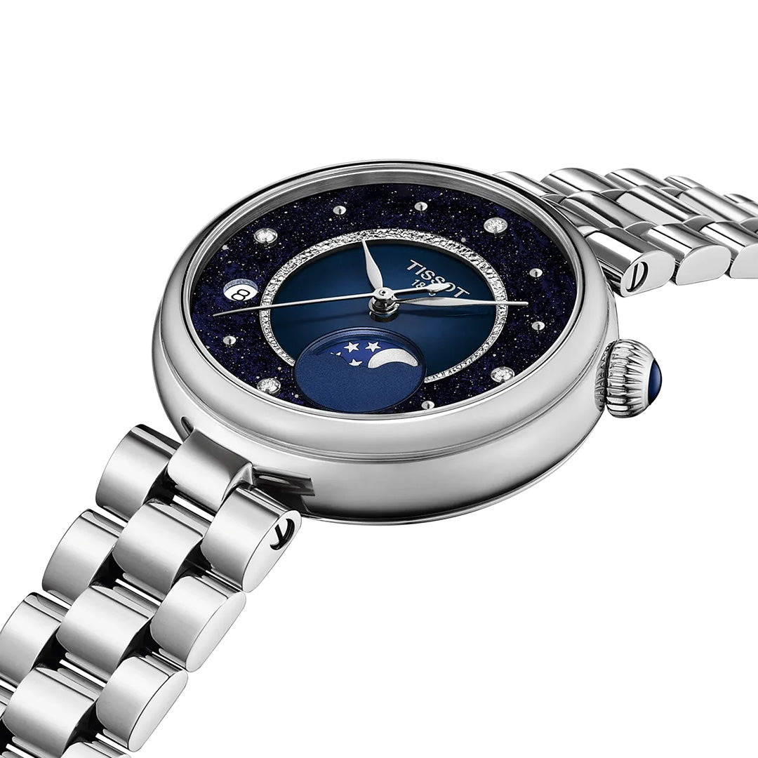 A Tissot Desir Moonphase Quartz 29.6mm watch featuring a starry night sky dial, moonphase display, diamond hour markers, and a diamond-accented stainless-steel bracelet is shown at an angle on a white background.