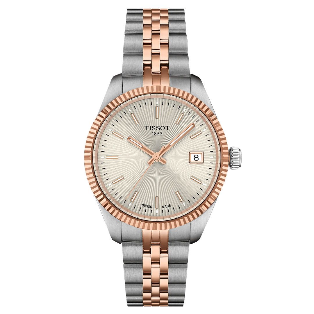 The Tissot Ballade Quartz 34mm Watch features a silver and rose gold two-tone metal band, a round guilloché dial with a rose gold bezel and hour markers, and displays the date at 3 o’clock.