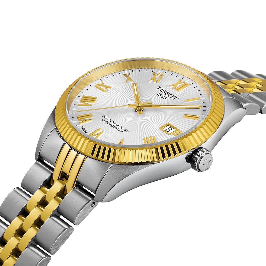 The Tissot Ballade Powermatic 80 Automatic 39mm features a silver dial with gold Roman numerals, fluted gold bezel, date at 3 o’clock, and two-tone bracelet. Chronometer-certified for precision by Tissot.
