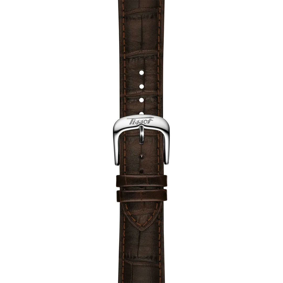 The Tissot Visodate Automatic 39mm Watch features a brown leather strap with crocodile pattern, visible stitching, and a silver buckle engraved with the Tissot logo, inspired by the classic Visodate collection.
