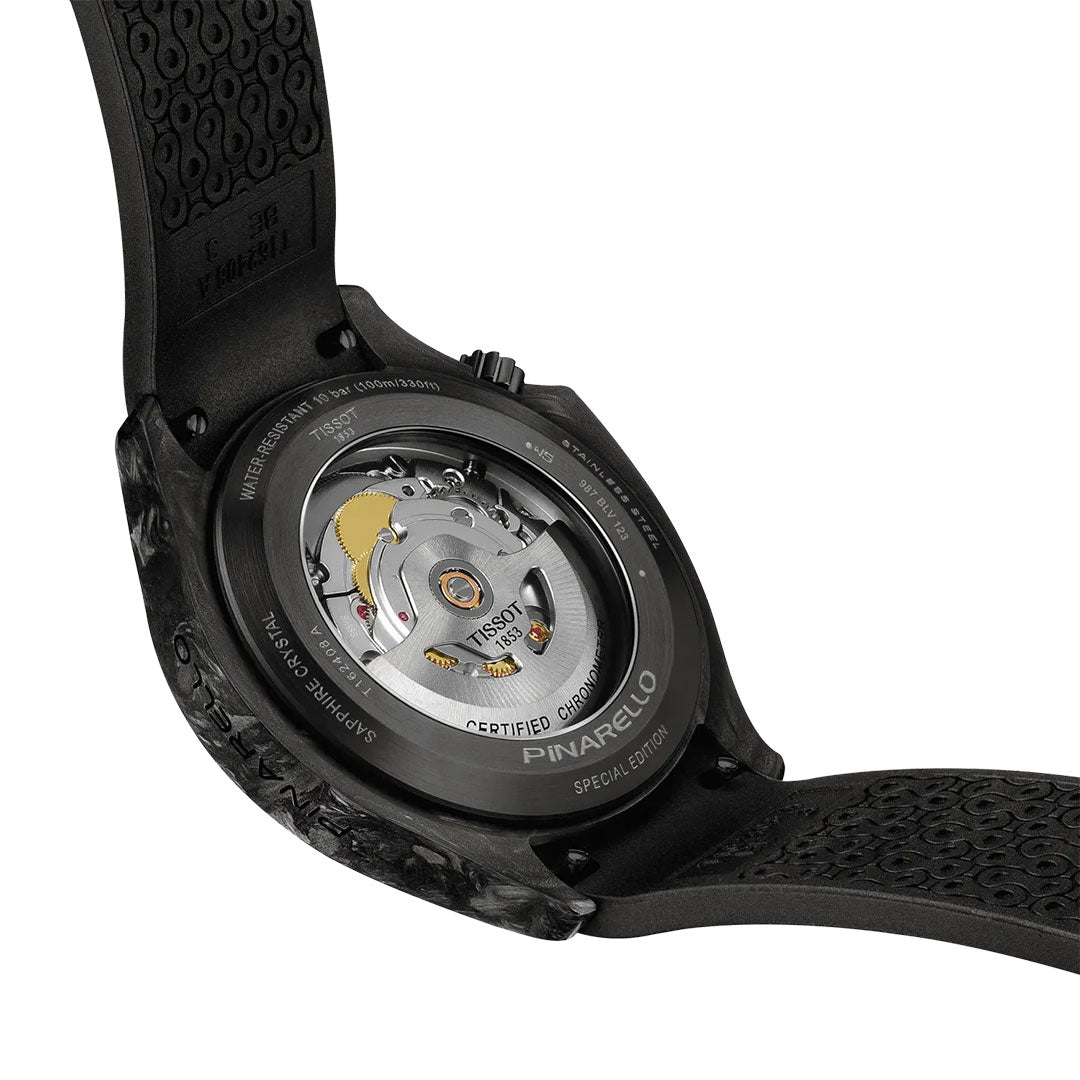 Close-up of the Tissot Pinarello Mechanical Automatic COSC 43mm Watch by Tissot, featuring an exposed mechanical movement, engraved details, a black textured strap, and a forged carbon case inspired by performance cycling.