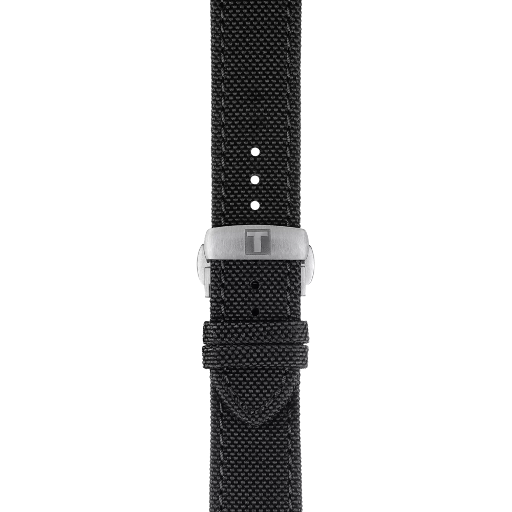 A close-up of the Tissot Official Black Fabric Strap (21 mm lugs) showcases its black textured material and silver buckle, which is engraved with the signature Tissot “T” logo.