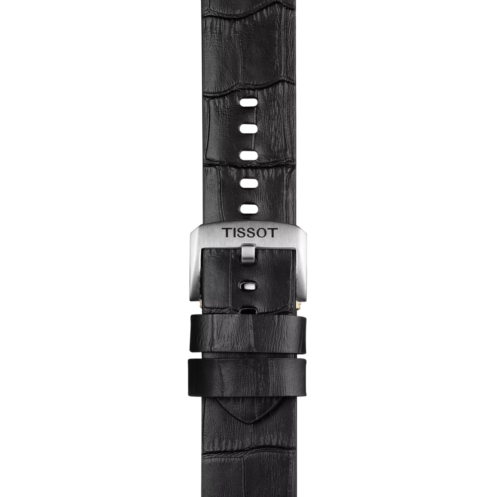 Close-up of the Tissot Official Black Leather Strap (22 mm lugs), featuring a textured, crocodile-like pattern and multiple adjustment holes. The black leather strap includes a silver buckle engraved with "TISSOT.