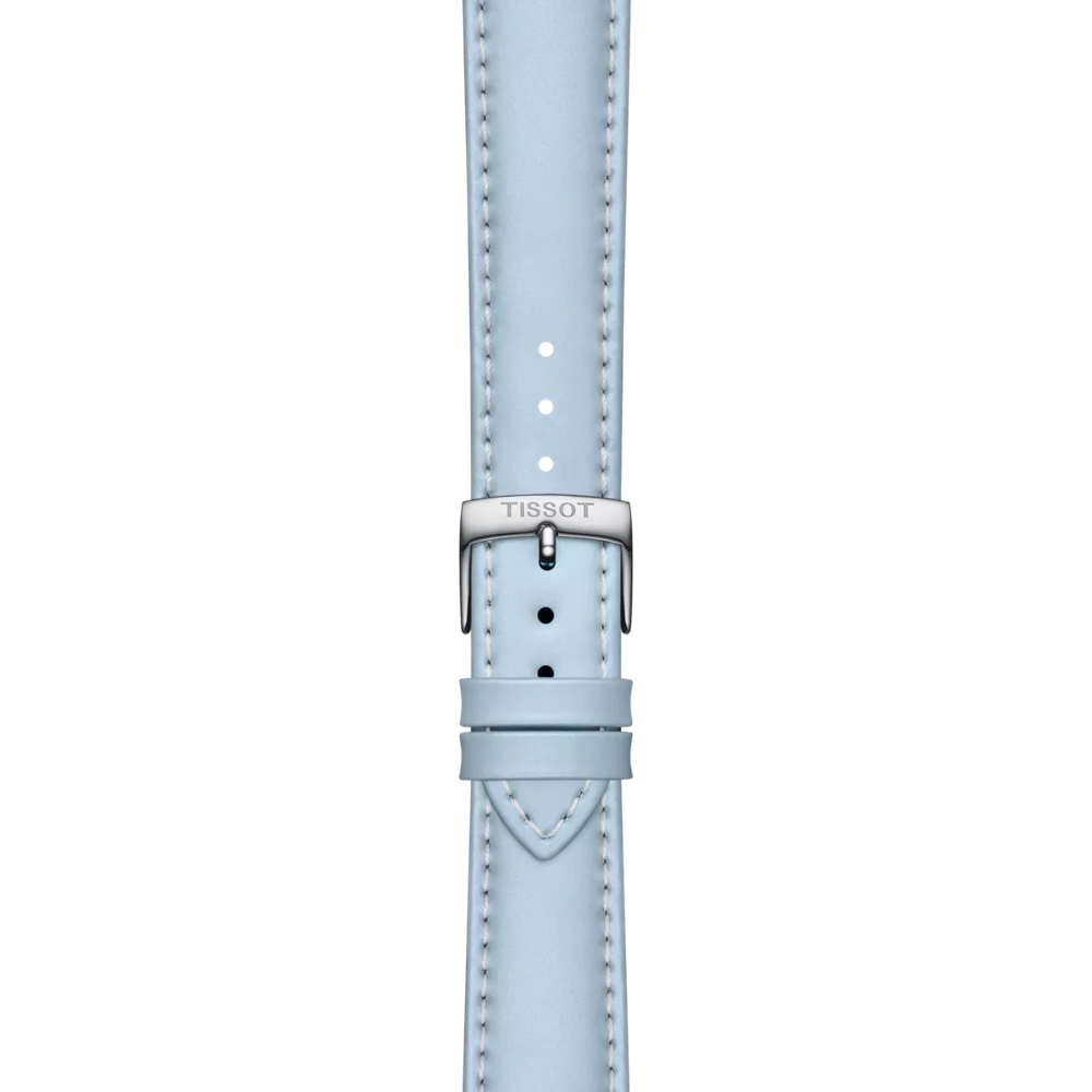 The Tissot Official Blue Leather Strap with 18 mm lugs features light blue leather, white stitching, and a silver buckle engraved with "TISSOT," displayed vertically against a plain white background.