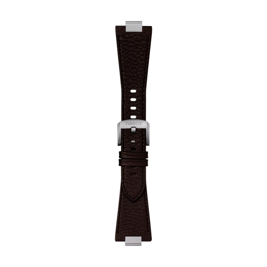 The Tissot Official Brown PRX 40mm Leather Strap, a dark brown textured leather watch strap, features silver end pieces and a silver buckle engraved with "TISSOT," and is displayed vertically on a plain white background.