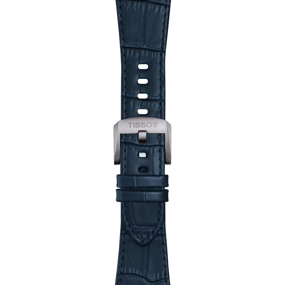 A close-up of the Tissot Official Blue PRX 42mm leather strap showcases its crocodile pattern, multiple adjustment holes, and a silver buckle engraved with "TISSOT.