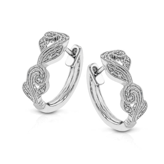 The Simon G. 18K White Gold Diamond Hoop Earrings from Simon G feature intricately designed, vintage-inspired swirling leaf patterns and milgrain-accented filigree. These earrings have a shiny finish and are displayed against a plain white background.