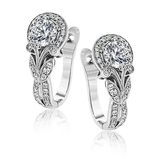 The Simon G 18K White Gold Sapphire with Diamonds Hoop Earrings are an elegant pair, featuring large round crystal-like sapphires at the top, surrounded by intricate leaf and vine designs with milgrain edging. These earrings have a shiny, sophisticated appearance enhanced by small diamond details.