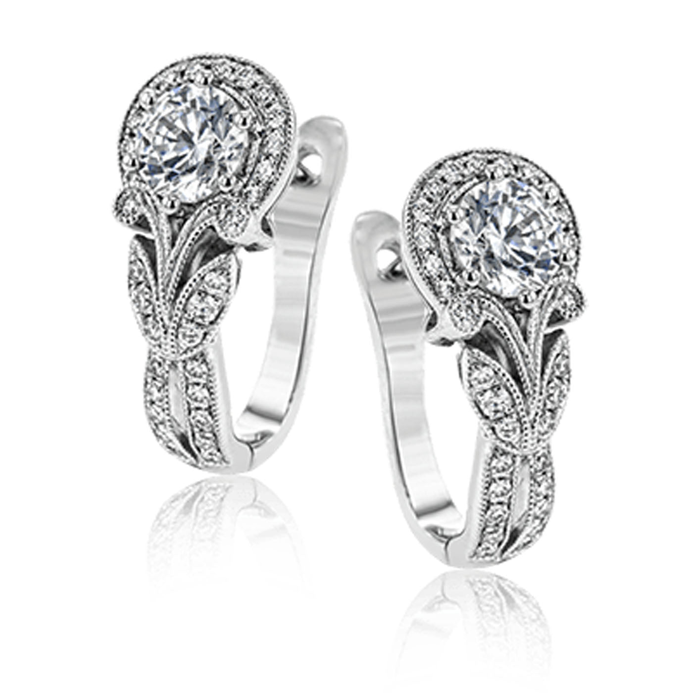 Introducing the Simon G. 18K White Gold Diamond Hoop Earrings, a masterpiece from Simon G. These earrings showcase large round diamonds on top and feature graceful milgrain edging. The design is enhanced with exquisite filigree detailing along the curved stems, complemented by smaller diamonds for extra sparkle.