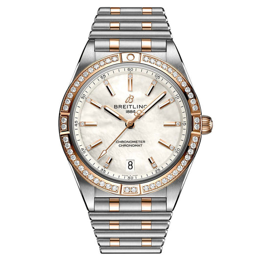 The BREITLING Chronomat Automatic 36 is a luxurious timepiece featuring a sophisticated silver and gold band, a white round face with gold markers, and diamond accents on the bezel. It elegantly displays the date and proudly presents the iconic Breitling logo at the top.