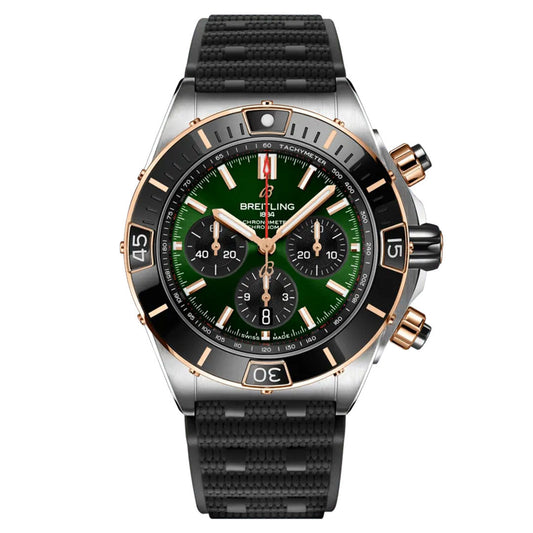 The BREITLING Chronomat B01 44 is a distinguished sports watch by Breitling, featuring a green and black dial with gold accents. It includes three subdials, a tachymeter scale, and is completed with a textured black strap and gold pushers for an exquisite finish.