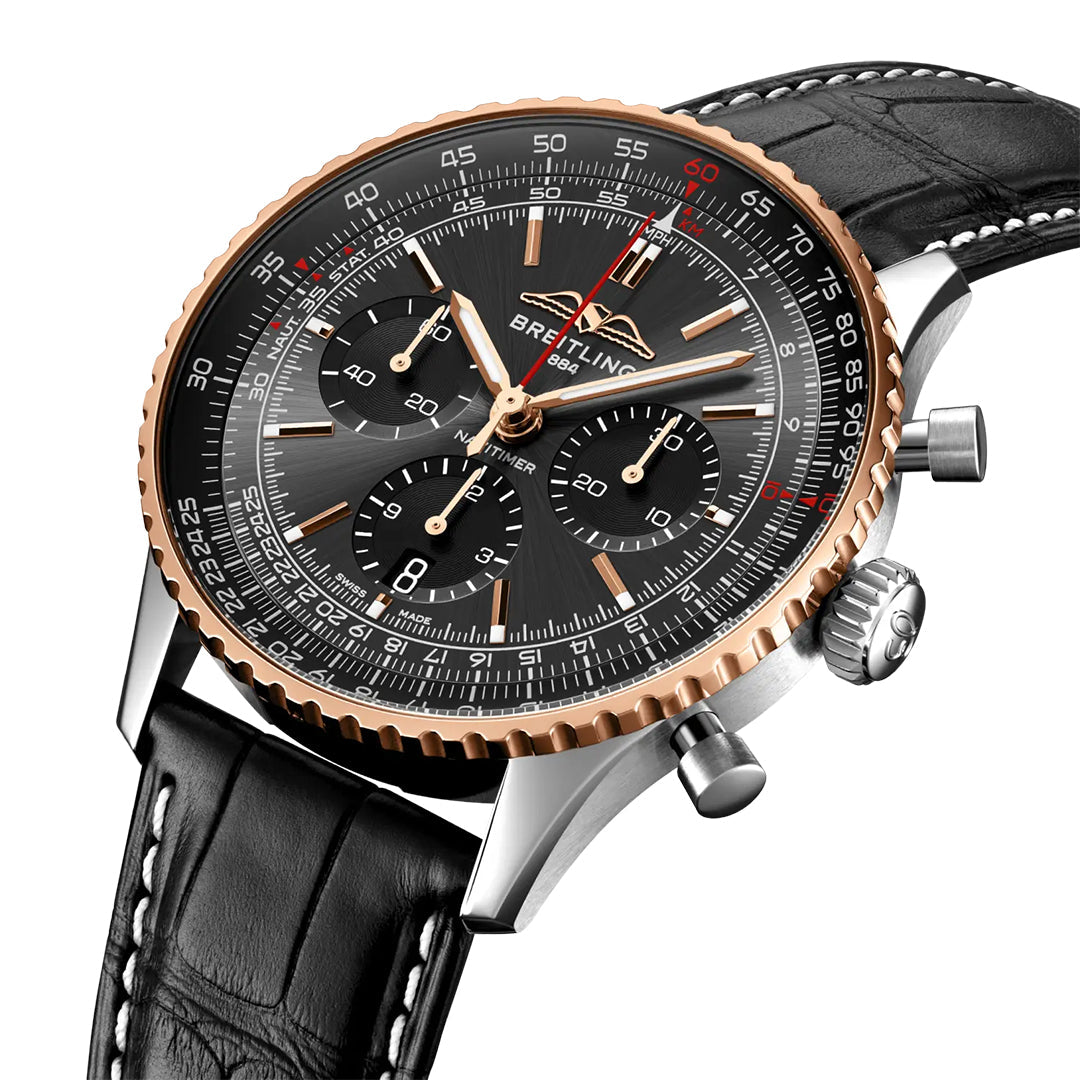 The Breitling Navitimer B01 Chronograph 43 Limited Edition is a luxury pilot’s watch featuring a black dial, three subdials, gold accents, a ridged gold bezel, and a black leather strap with white stitching.