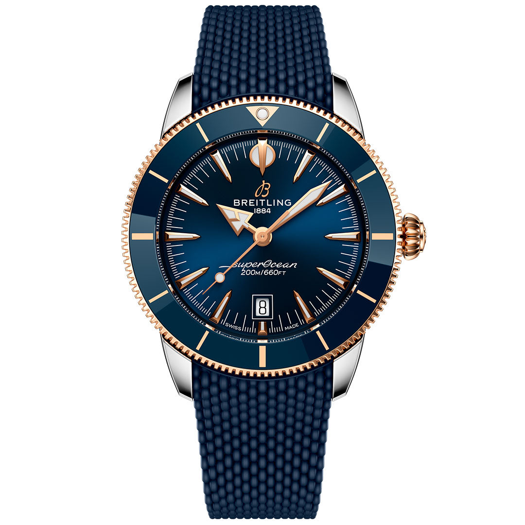 The Breitling Superocean Heritage B31 Automatic 44 is a luxury dive watch featuring a blue textured strap, blue dial and bezel with gold accents, automatic movement, date at 6 o’clock, and 200m/660ft water resistance.
