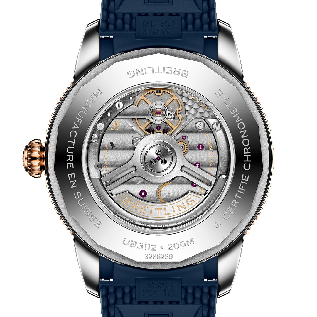 Close-up of the back of the Breitling Superocean Heritage B31 Automatic 44, displaying its intricate automatic movement through a transparent caseback with engraved details and an attached blue rubber strap.