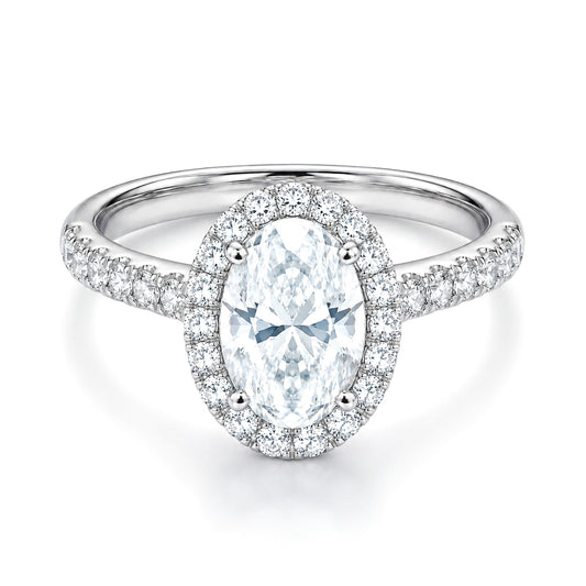 The Raffi&Co.® 14K White Gold Oval Halo Diamond Engagement Ring showcases a stunning 3.56 ct oval diamond, surrounded by a halo of smaller diamonds and more diamonds set along the band.