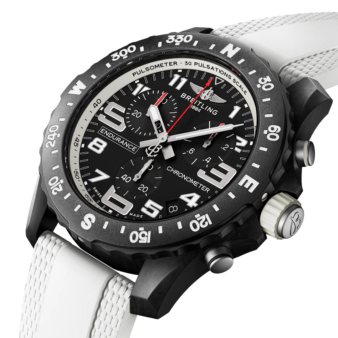 A close-up of the Breitling Endurance Pro 44 shows its black dial, large white numerals, three subdials, rotating bezel, and textured white strap. Crafted from ultra-light Breitlight®, it features a pulsation scale and chronograph functions.
