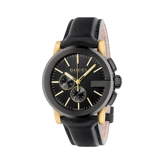 The Gucci G-Chrono Quartz 44mm Watch by GUCCI Watch showcases a contemporary design with a round gold and black face, two sub-dials, and a stylish leather strap. Its G-shaped bezel beautifully accents the gold watch hands and hour markers set against a textured black dial.