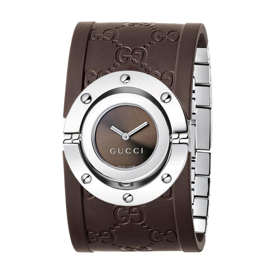 The Gucci Twirl Quartz 24mm Watch from GUCCI features a modern and sophisticated design, with a round stainless steel case, a brown dial adorned with the Gucci logo, and a wide brown rubber strap embossed with the iconic GG pattern.