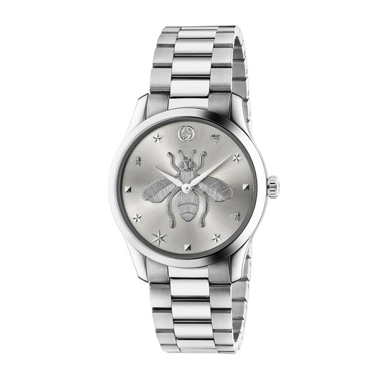 The Gucci G-Timeless Quartz 38mm Watch by GUCCI features the signature bee design on its face, adorned with delicate star and bee motifs. Its silver wristwatch style is enhanced by a metal bracelet and a sleek bezel that complements the detailed G-Timeless dial.