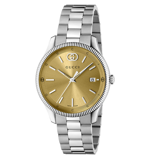 The Gucci G-Timeless Quartz 38mm Watch, a luxury timepiece by GUCCI Watch, features a two-tone metal bracelet and a round, gold-toned dial with minimalist hour markers. It includes a date display at 3 o'clock and the brand logo at 12 o'clock. Its finely ridged bezel enhances its sophisticated Swiss Made design.