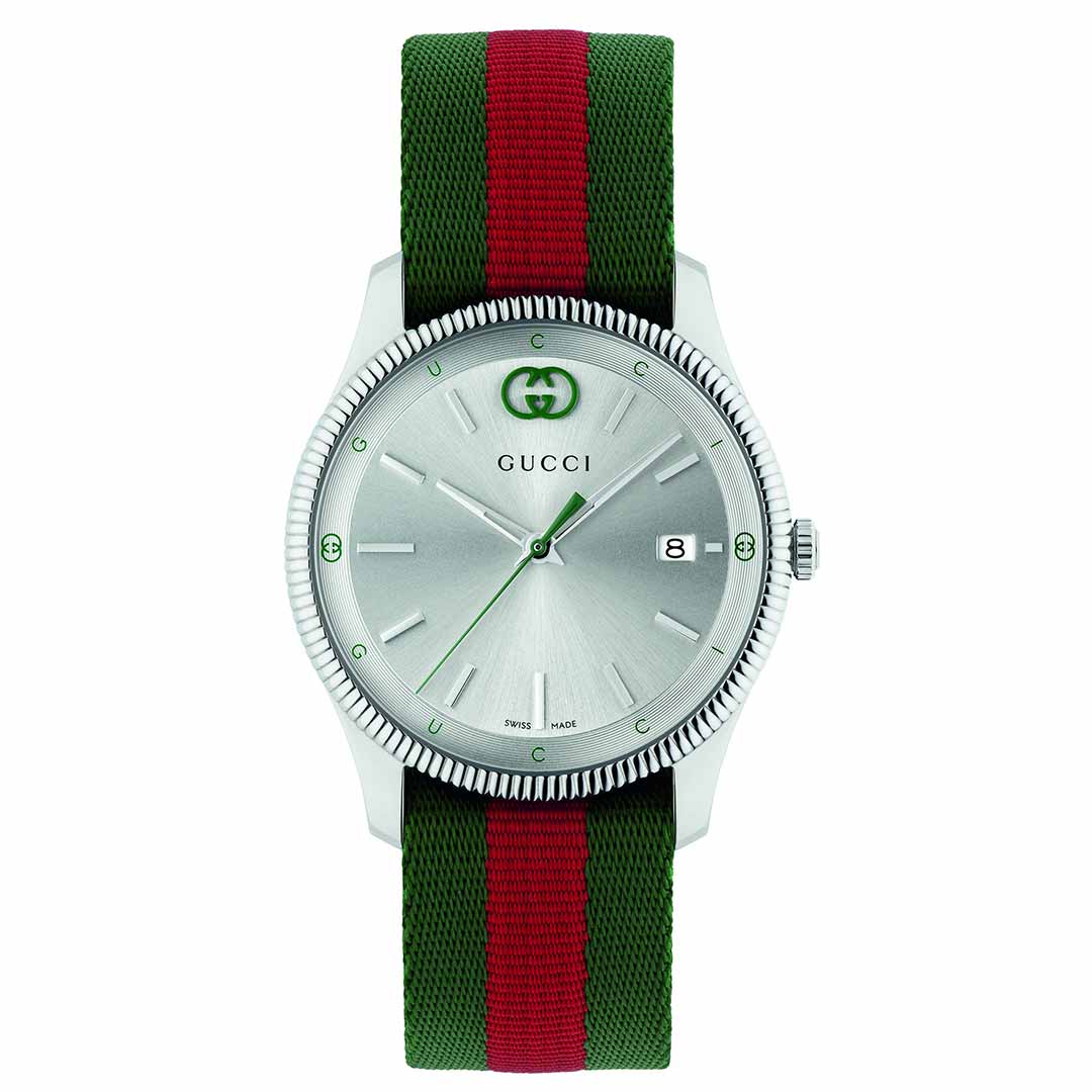 The Gucci G-Timeless Quartz 38mm Watch features a stainless steel case and minimalist design. Its silver round face is complemented by a green and red nylon strap, with the iconic GUCCI Watch logo on the dial, along with slim hands, markers, and a convenient date display.