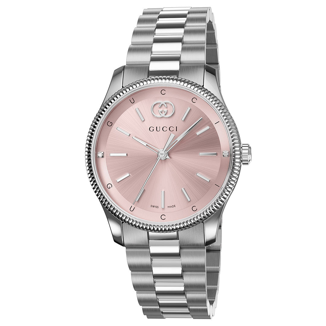 The Gucci G-Timeless Quartz 29mm Watch features a stainless steel bracelet, round pink sunburst dial with silver hour markers, slim hands, and the GUCCI logo at 12 o’clock.