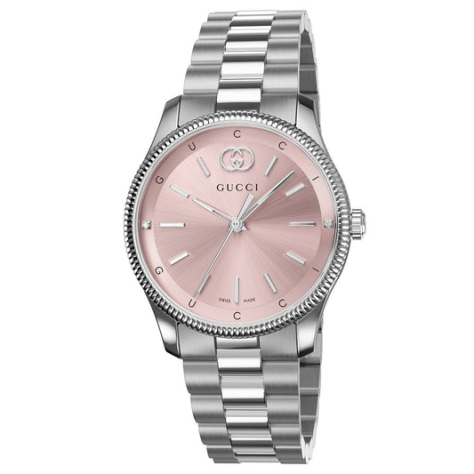 The Gucci G-Timeless Quartz 29mm Watch features a stainless steel bracelet, round pink sunburst dial with silver hour markers, slim hands, and the GUCCI logo at 12 o’clock.