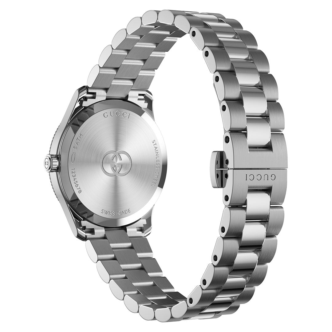 A GUCCI G-Timeless Quartz 29mm Watch in silver stainless steel is shown from the back, showcasing its engraved case back and a clasp featuring the Interlocking G Gucci logo on the bracelet.