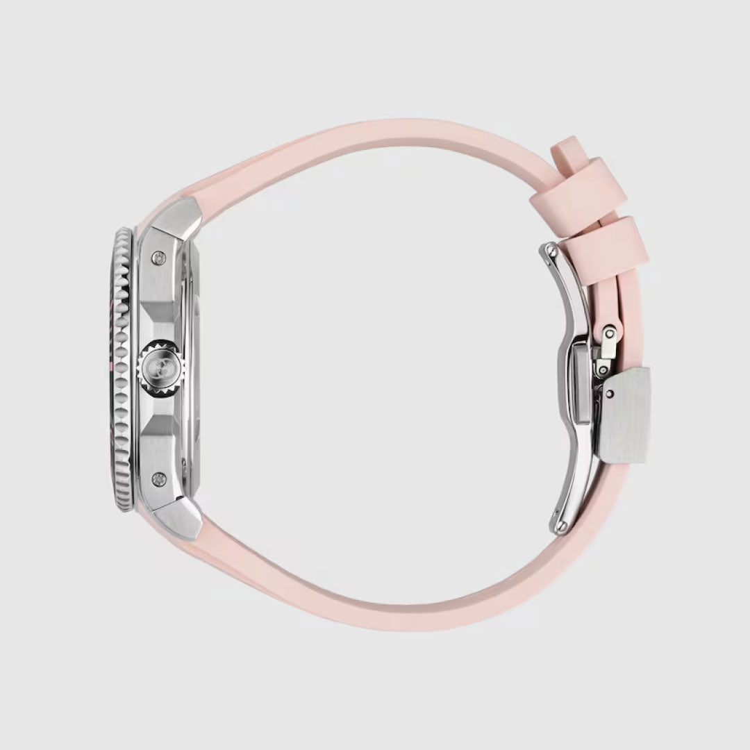 Side view of the Gucci Dive Automatic 36mm Watch by GUCCI, with a silver case, textured crown, pink rubber strap, and automatic movement, set against a plain light background.