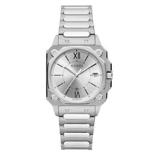 The GUCCI G-Flat Quartz 30mm Watch features a silver stainless steel bracelet, square case, round silver dial with Roman numeral XII, date window at 3 o’clock, and minimalist hour markers.