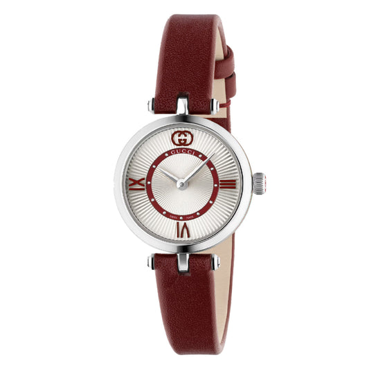 The Gucci Model 2000 Quartz 24mm women's watch from the Cruise 2025 collection has a round silver dial with Roman numerals, a brown leather strap, and features the red Gucci logo, Swiss craftsmanship, Italian style, and an elegant decorative inner circle.