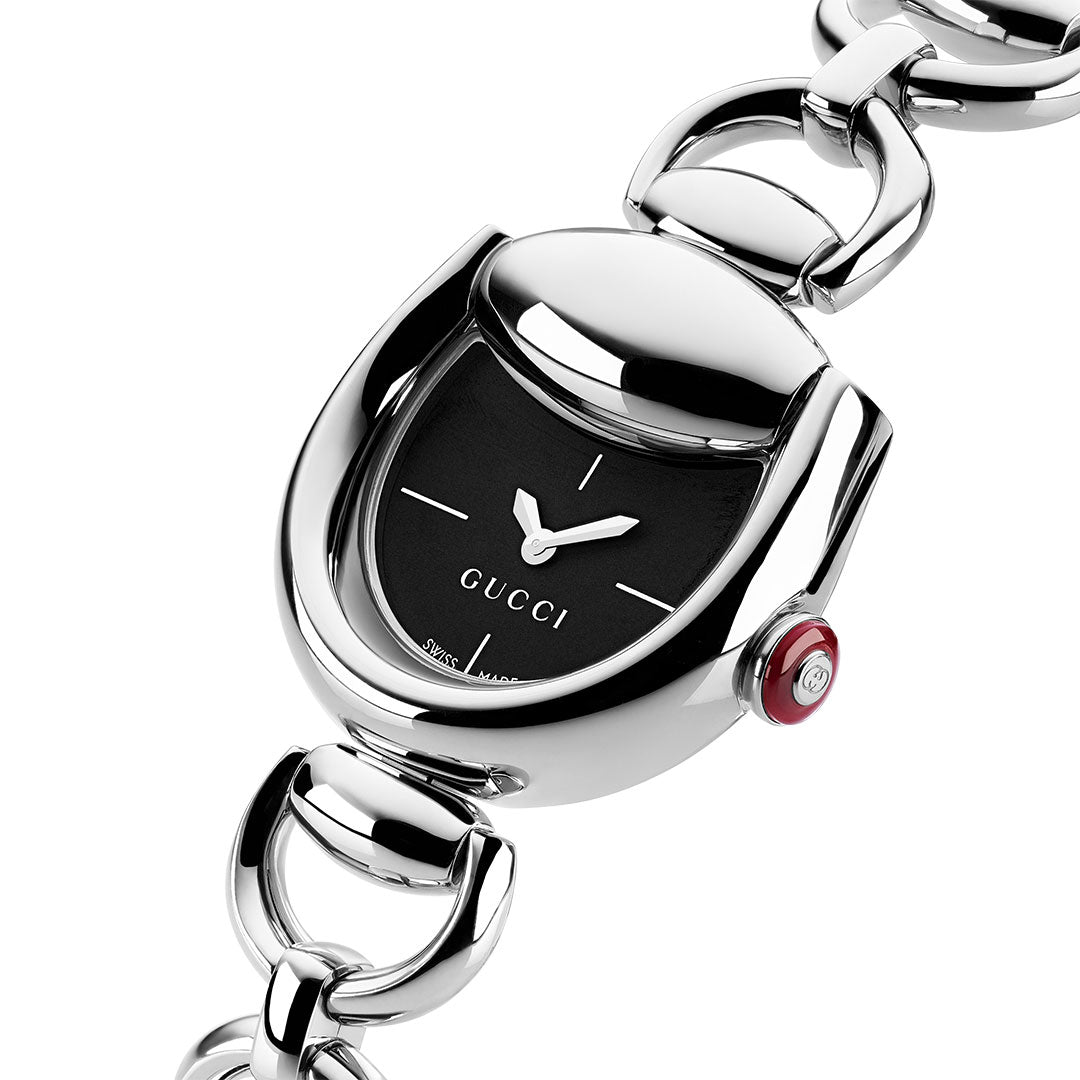 A close-up of the Gucci Horsebit Quartz 27mm x 25mm Watch by GUCCI, featuring a black oval face, minimalist silver hands, a horsebit chain bracelet, and a Swiss Made design with a red crown engraved with the Gucci logo.