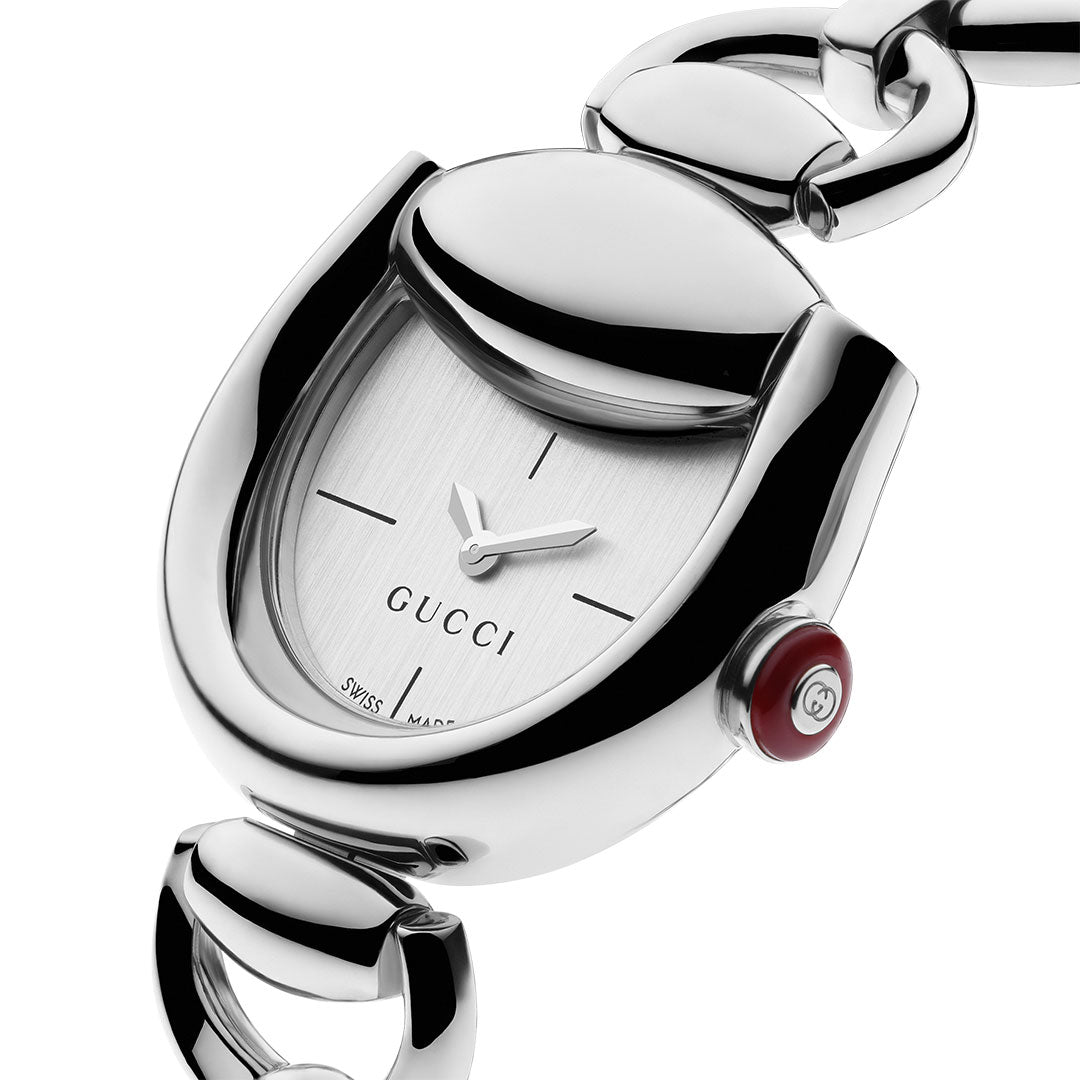 Close-up of the Gucci Horsebit Quartz 27mm x 25mm Watch by GUCCI, featuring a unique rounded case, minimalist silver dial with black hour markers, red crown, and a polished stainless steel bracelet with large interconnected links.