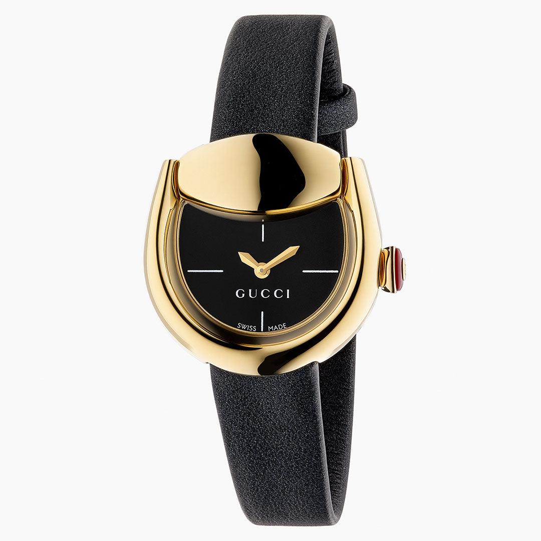 The Gucci Horsebit Quartz 27mm x 25mm Watch features a yellow gold-plated case, black dial with minimalist hour markers, gold hands, a black leather strap, and a crown with a red accent for flair.