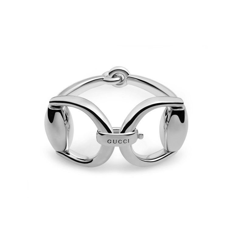 Introducing the Gucci Horsebit Sterling Silver Bangle from GUCCI Fine Jewellery—a radiant piece of sterling silver jewelry with a sleek and contemporary design. It features interconnected, polished metal links and a discreet Gucci logo at its core. This elegant bangle embodies the iconic style that is quintessential to the brand's Horsebit collection.