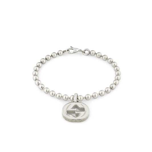 The Gucci Interlocking G Sterling Silver Bead Bracelet by GUCCI Fine Jewellery features round beads and a lobster clasp, elegantly supporting a circular pendant.