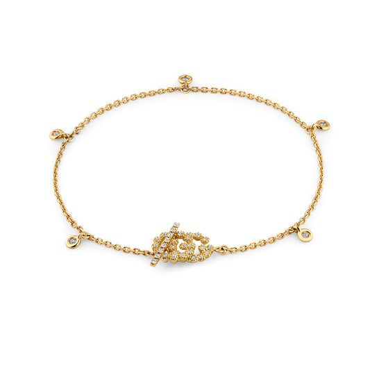 Introducing the GUCCI Fine Jewellery creation: the Gucci Running G 18K Yellow Gold Diamond Charm Bracelet. This exquisite bracelet features a delicate chain adorned with a central leaf design embellished with small diamonds, complemented by additional diamond charms evenly spaced along the chain for added elegance.